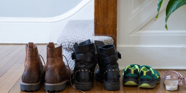 Family of four shoes lined up at foot of staircase.